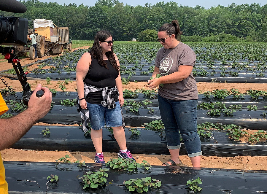 Jillian and Katie talk while standing in a farm field.