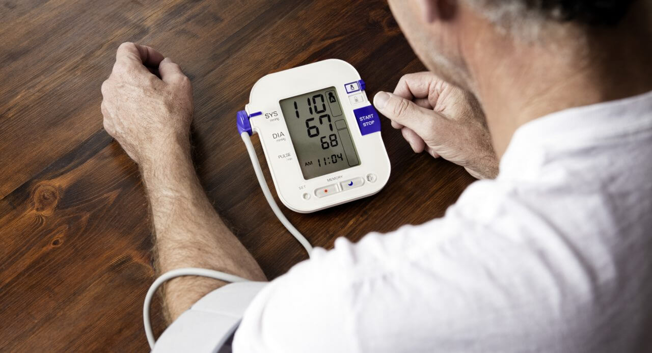 A blood taking his blood pressure on a machine at home