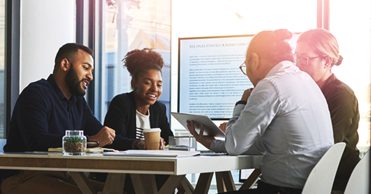 Four employees sitting in a meeting